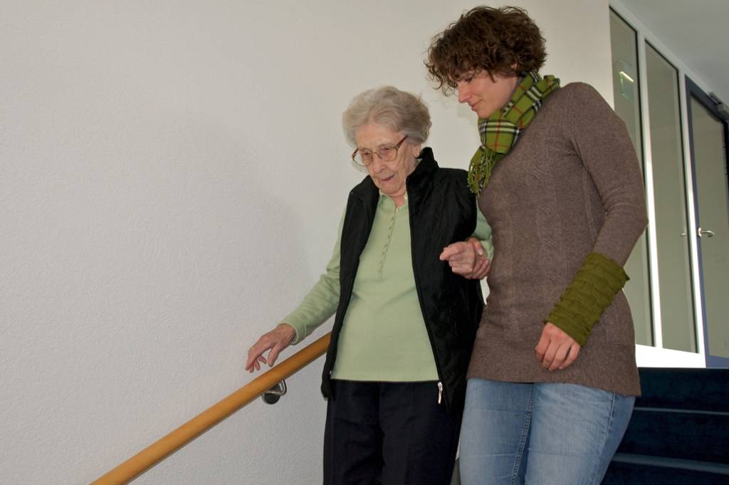 Begleitung Hannover – Betreuungskraft begleitet Seniorin beim sicheren Treppensteigen